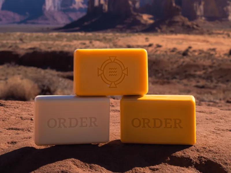 Three Order Soap bars stacked on red desert rock