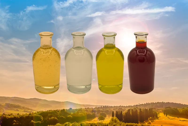 Four bottles of organic oil against a sunrise over the hills